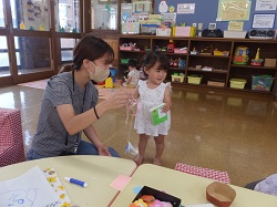 お母さんが子どもにどうぶつふうりんをみせるようす