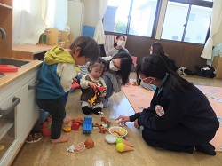 中学生と子どもたちがおもちゃで遊ぶようす